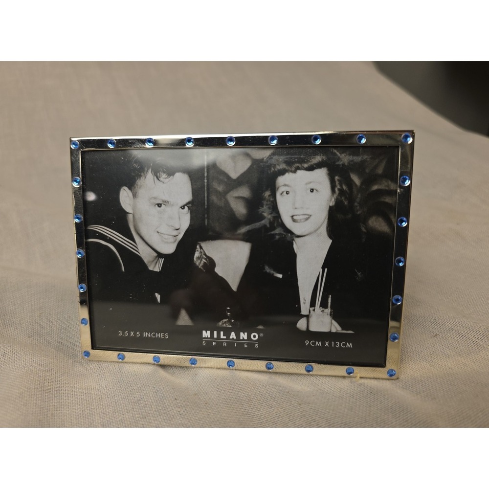 Mid-Century Hollywood Regency frame with polished metal and blue jewel insets.‎